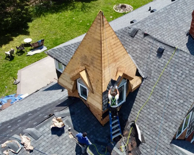 Home Vision Contracting crew applying weatherproof underlayment on pitched roof
